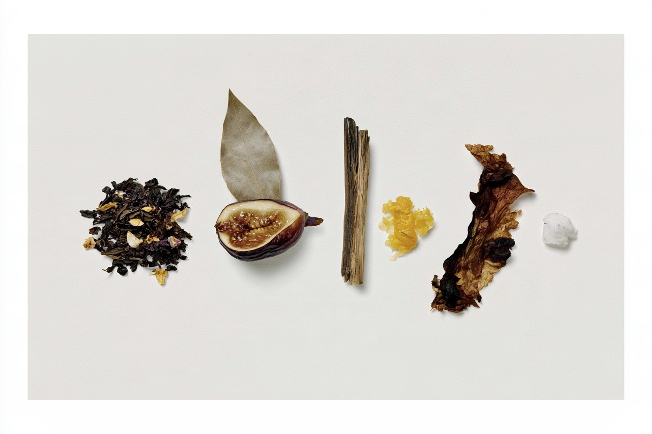 Ingredients laid out in a row: black tea, fig, bay leaf, cedar, amber, tobacco, musk